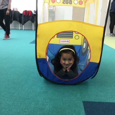 Young girl in tunnel smiling with chin in hands