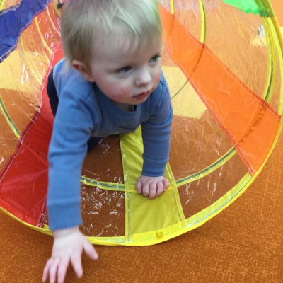 Toddler climbing out of tunnel