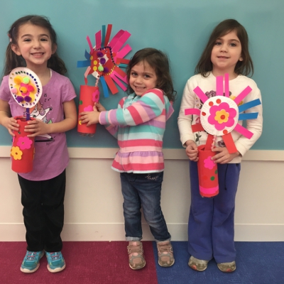 Three young girls holding their spring flower crafts