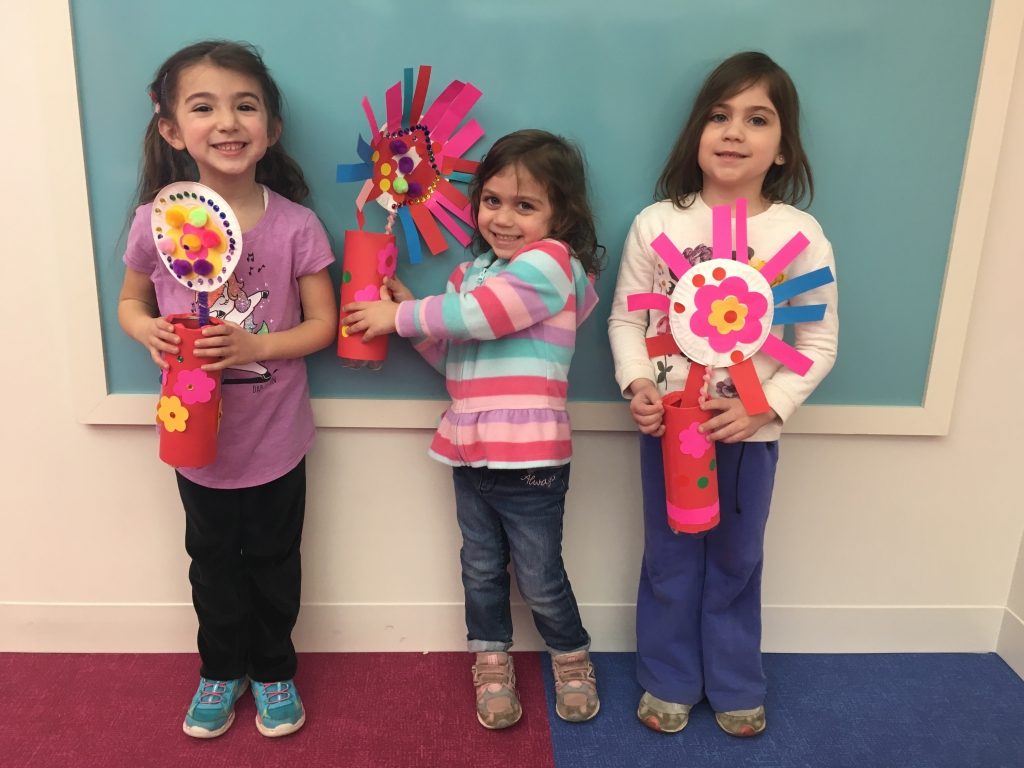 U Make It Craft Time Three young girls holding their spring flower crafts